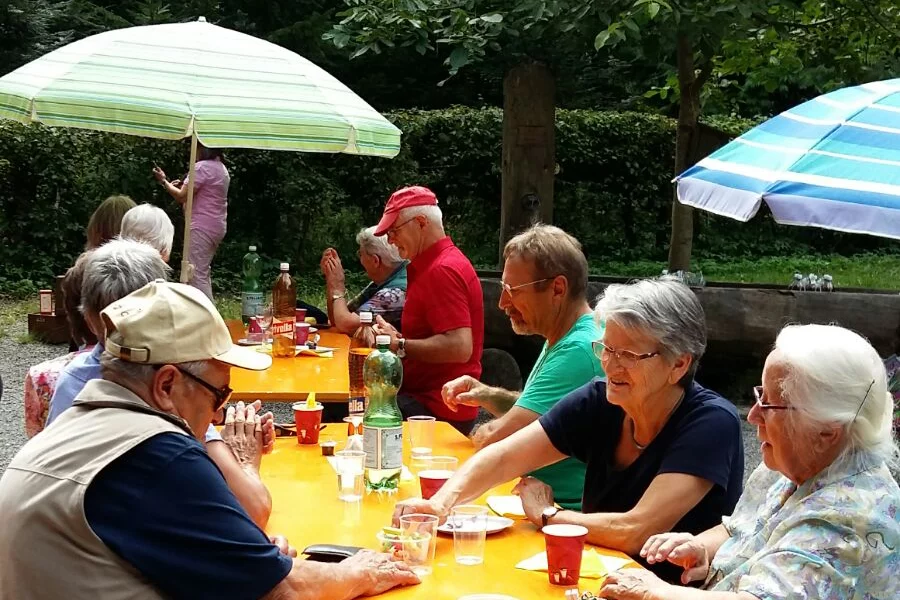 Vereinsanlass PA Zofingen, eine Gruppe Menschen sitzt an Festbänken und unterhält sich